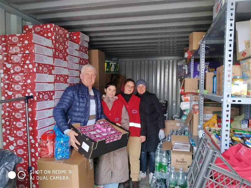 Slavic (left) and volunteers unload the supplies into the UNHCR container