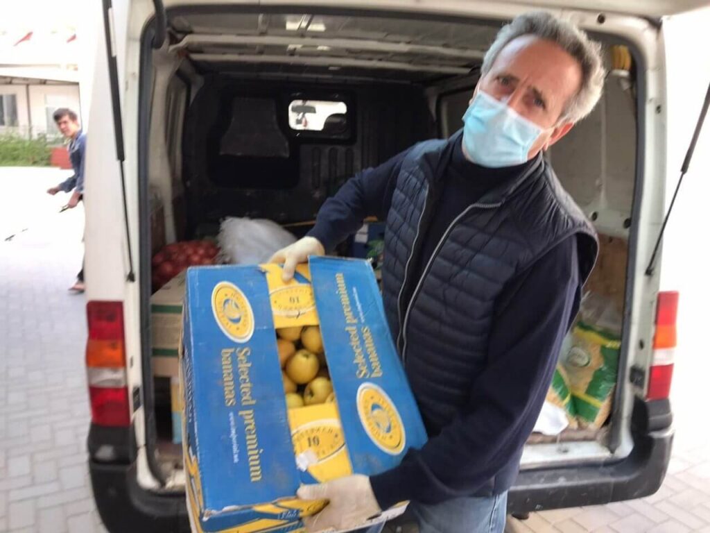 Unloading items from the UDG van for packing into bags for families